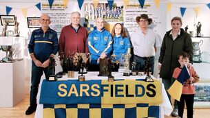 <p>Sarsfields LGFA committee members Ray Curham, founding members Michael O'Loughlin and Jim Halley, Orla Payne (treasurer) Michael Dowling, multi-medalist Ciara O'Loughlin and her son Shay waving the Sarsfields' flag Photo: Stan Henderson</p>