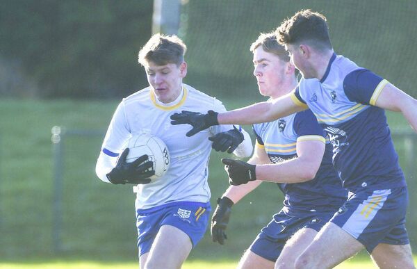 Frank Delaney (Mountmellick CS) retains possession despite these challenges Photo: Denis Byrne