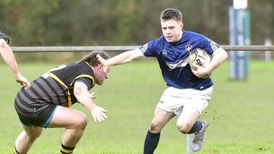 <p>Portlaoise scrumhalf Jake Byrne hands off this attempted tackle in the Leinster League Division 2B win over Garda at Togher on Sunday Photo: Denis Byrne</p>