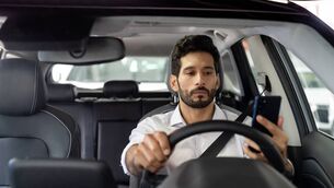 <p>Crowdsourced taxi driver using a mobile app on his cell phone while driving -mobility as a service concepts</p> <p>Crowdsourced taxi driver using a mobile app on his cell phone while driving -mobility as a service concepts</p>