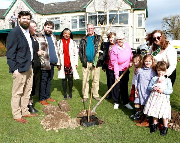 Mary Fallon pictured with family members as she plants a tree 