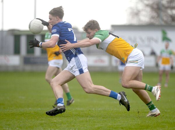 Laois's Simon Fingleton in full flight despite the best effort of Offaly's Rory Egan to halt his progress Photo: Denis Byrne