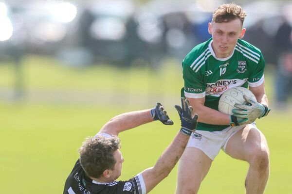 Portlaoise's Josh Hogan hangs on to possession despite this challenge Photo: Paul Dargan