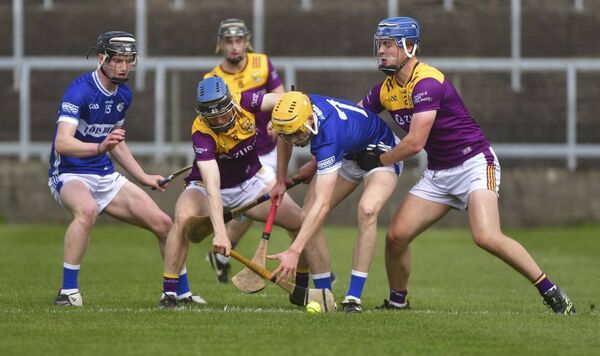 Oisin McRedmond (Laois) looking to gain possession as Wexford players challenge	Photo: Denis Byrne