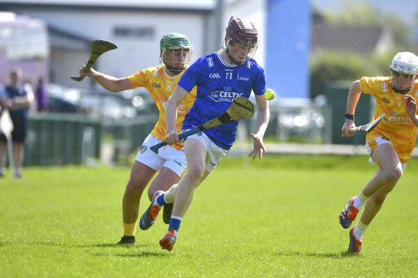 Cillian Dunne (Laois) breaking with Antrim's Lorcan Murtagh giving chase Photo: Denis Byrne