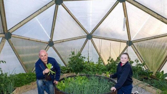 <p>Noel Fennelly and Orlaith Headen pictured in 2025, with produce in the Knock Vintage Club Men's Shed Geodome. Photo: Alf Harvey</p>