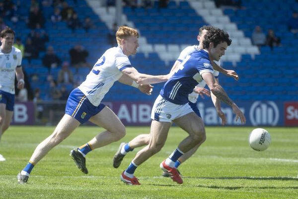 Laois's Darragh Galvin chases down the football with two Wicklow men just behind.
