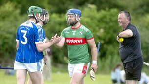 <p>All Smiles - Liam O'Connell (Rathdowney/Errill) and Shane Phelan (Castletown) ahead of their ACHL Division 1 match at Errill as referee John Lalor looks on Photo: Denis Byrne</p>