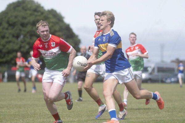 Finn Craig (O'Dempsey's) looking to lay this ball off as Darragh Scully (Clonaslee/St Manman's) moves in to challenge 	Photo: Denis Byrne