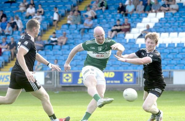 Ciaran McEvoy (Portlaoise) blasts this ball on goal as Enda O'Rourke (Arles Killeen) attempts to block Photo: Denis Byrne Ciaran McEvoy (Portlaoise) blasts this ball on goal as Enda O'Rourke (Arles Killeen) attempts to block Photo: Denis Byrne