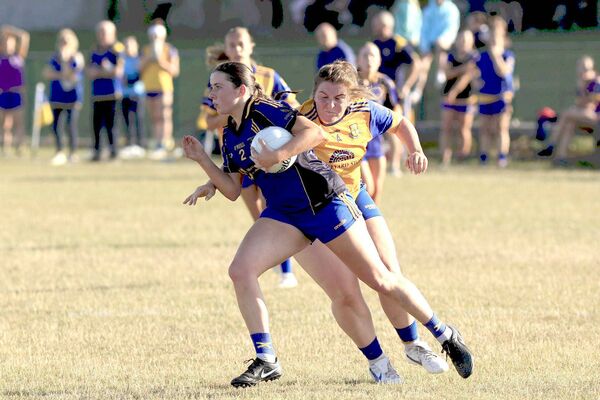 Sarsfields' Julie Anne Bennett drives through Caoimhe Farrell's (St Joseph's) challenge 	 Photo: David Maher
