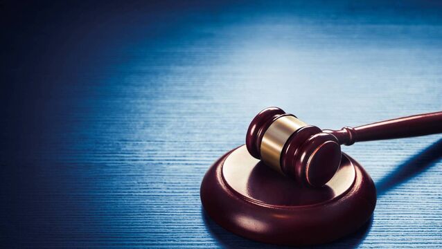 <p>high contrast image of Judge gavel on a blue wooden background</p>