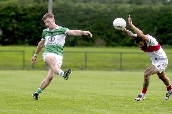 Jimmy Hyland (Rosenallis) playing this ball on goal as Cian Langford (Emo) moves to block in their SFC 'B' semi-final 	Photo: Denis Byrne