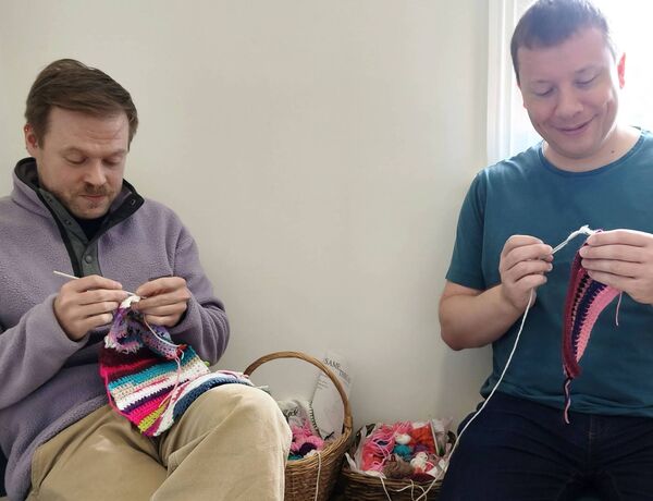 Julius Szabo and Robert O'Connor adding a few stitches to the pieces that are in the interactive area for visitors to add to while viewing the exhibition Julius Szabo and Robert O'Connor adding a few stitches to the pieces that are in the interactive area for visitors to add to while viewing the exhibition
