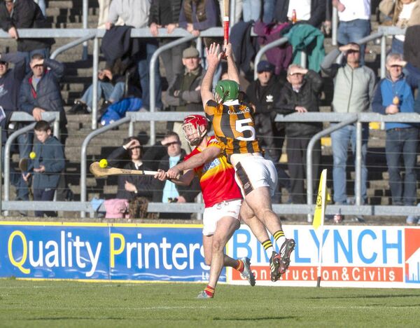 Ciaran Comerford (Harps) playing this sliotar as Eoghan Cuddy (Camross) dives to block Photo: Denis Byrne Ciaran Comerford (Harps) playing this sliotar as Eoghan Cuddy (Camross) dives to block Photo: Denis Byrne