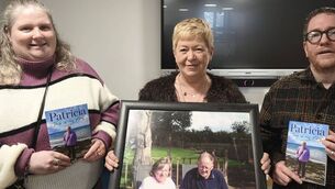 <p>Patricia's friend Amy O'Brien, author Patricia Dempsey holding a photo of her parents to whom she dedicated the book to and David Delaney who launched the memoir in Portlaoise Library </p>